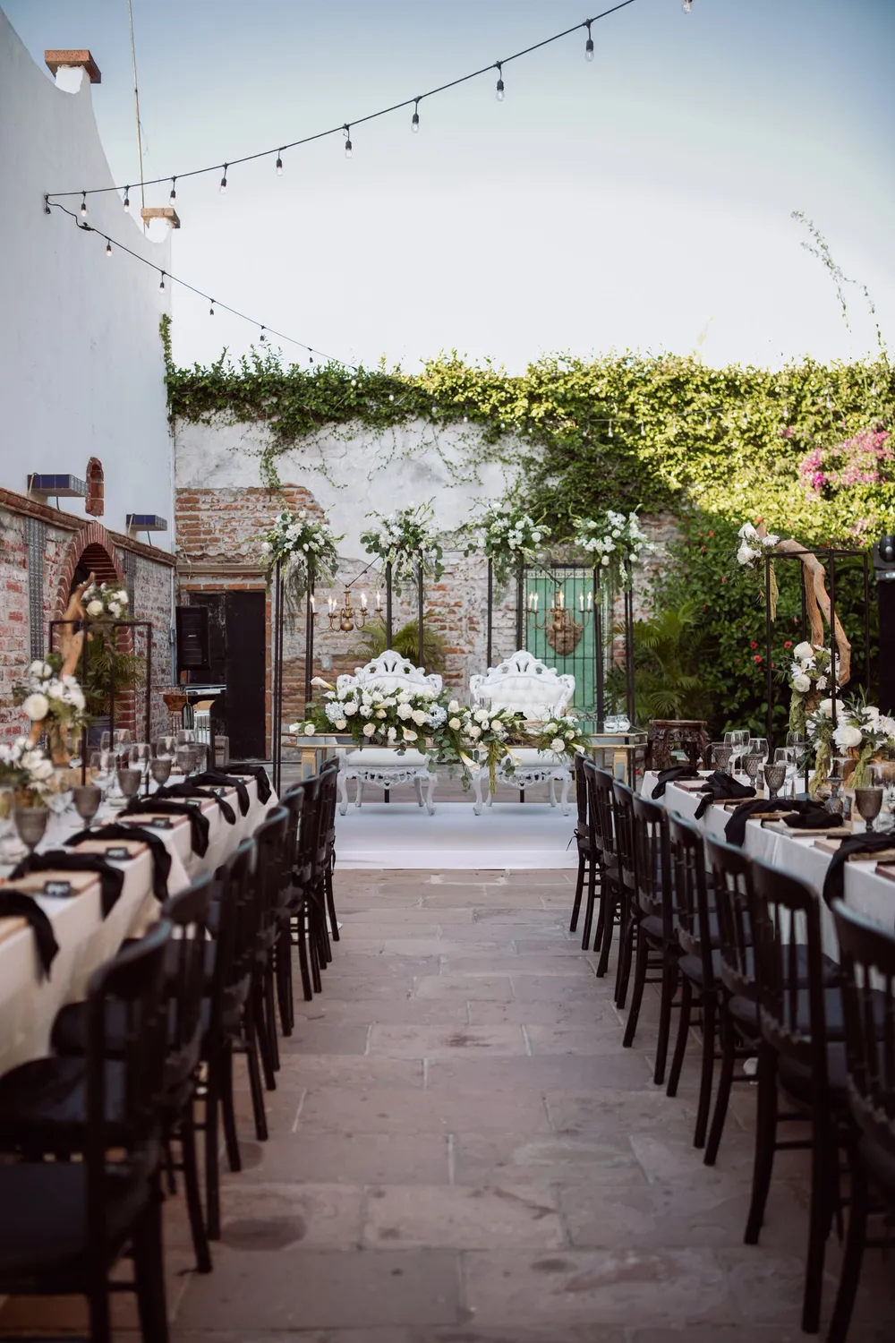 Courtyard reception with long tables and string lights