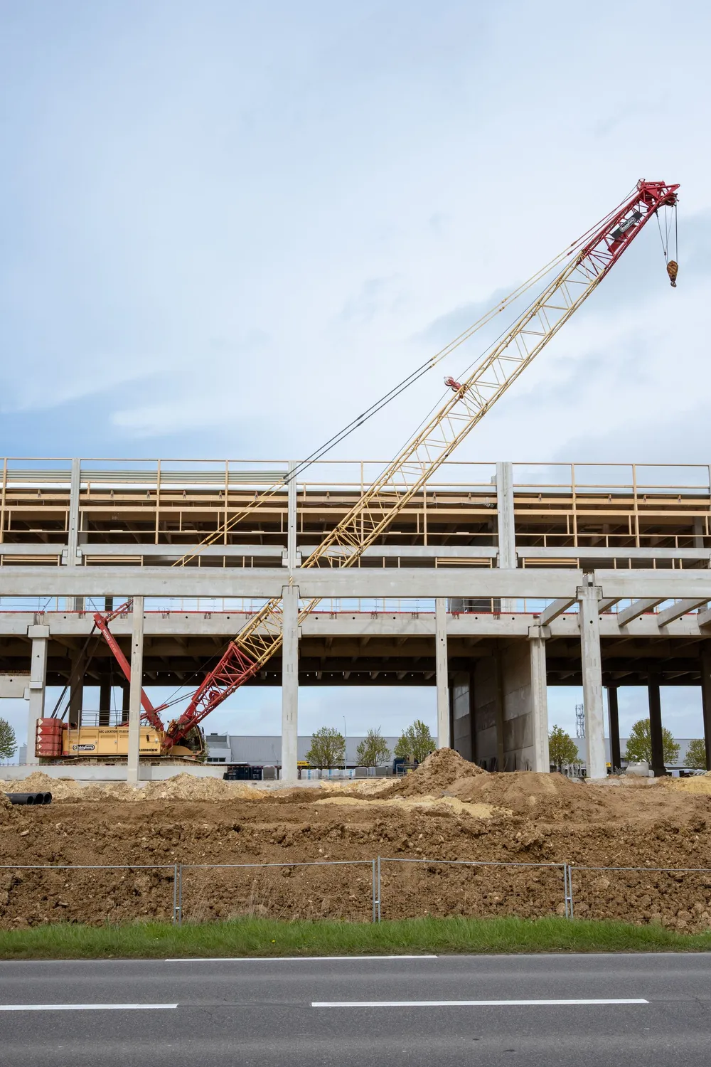 Construction site with a crawler crane beside a new building frame
